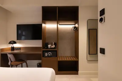 a room with a desk and a table with a television at Moontels Colón in Valencia