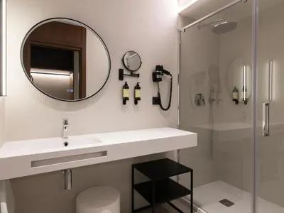 a bathroom with a sink and a mirror and a shower at Moontels Colón in Valencia
