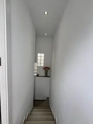 a hallway with white walls and stairs with a window at Casa moderna en Manises con 2 terrazas in Manises