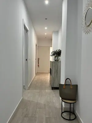 a hallway with a table and a chair with a purse at Casa moderna en Manises con 2 terrazas in Manises