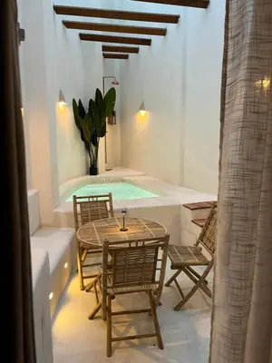 a patio with a table and chairs and a swimming pool at Apartamento acogedor frente a Plaza de la Iglesia in Valencia
