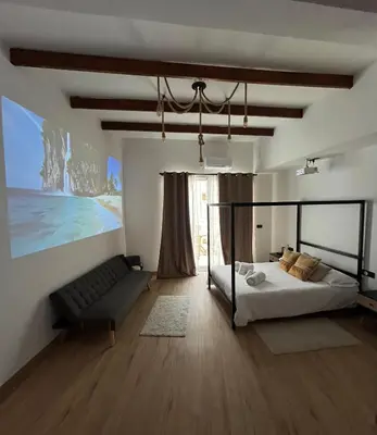 a bedroom with a bed and a couch at Apartamento acogedor frente a Plaza de la Iglesia in Valencia
