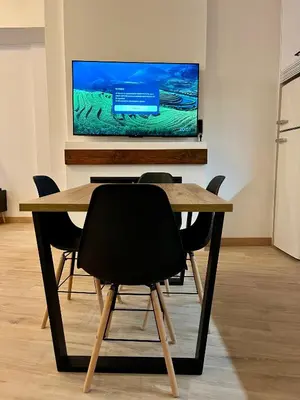 a dining room table with chairs and a flat screen tv at Apartamento acogedor frente a Plaza de la Iglesia in Valencia