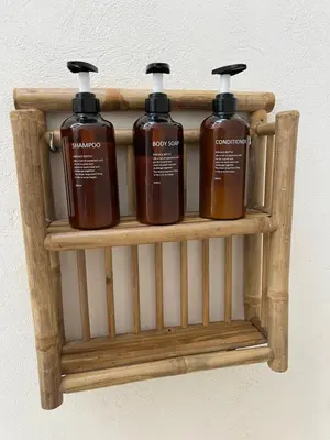 three bottles of soap on a wooden shelf at Apartamento acogedor frente a Plaza de la Iglesia in Valencia