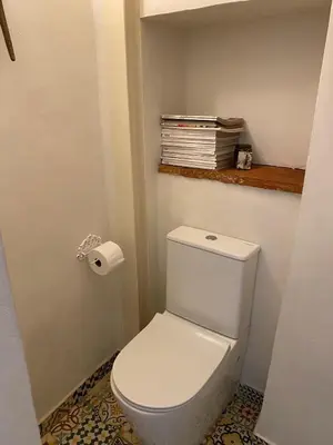a white toilet in a bathroom with a roll of toilet paper at Casa Albacora 1892 in Losa del Obispo