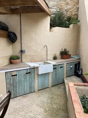 an outdoor kitchen with a sink and potted plants at Casa Albacora 1892 in Losa del Obispo