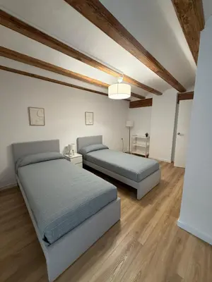 two beds in a room with wooden ceilings and wooden floors at K&A Apartments in Valencia