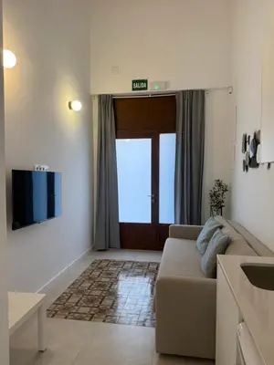 a living room with a couch and a sliding door at K&A Apartments in Valencia