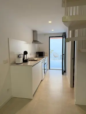 a kitchen with white cabinets and a view of the ocean at K&A Apartments in Valencia