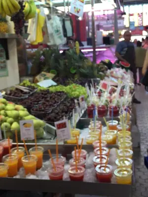 a market with a bunch of fruits and vegetables and drinks at Window to Central Market in Valencia