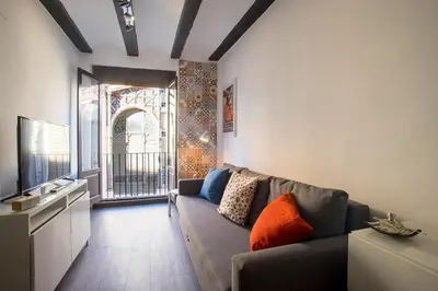 a living room with a couch and a large window at Window to Central Market in Valencia
