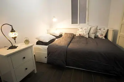a bedroom with a bed and a night stand with a lamp at Window to Central Market in Valencia