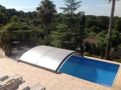 a white swimming pool with chairs and trees at Casita Ramona in Valencia