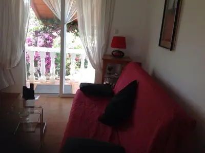 a living room with a red couch and a glass table at Casita Ramona in Valencia