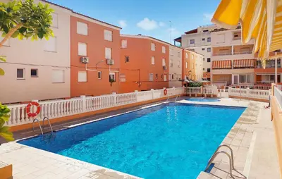 a swimming pool in front of some buildings at Stunning Apartment In Moncofa With Swimming Pool in Moncófar