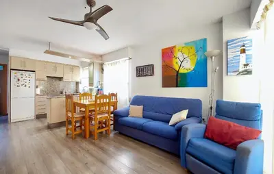 a living room with a blue couch and a kitchen at Stunning Apartment In Moncofa With Swimming Pool in Moncófar