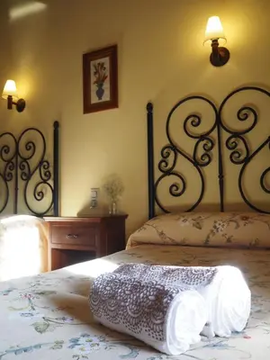 a bedroom with a bed with a white bedspread at La Ontina Alojamientos Rurales in Abejuela