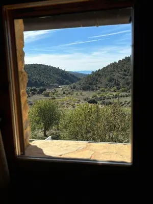 a window view of a valley from a mountain at La Ontina Alojamientos Rurales in Abejuela