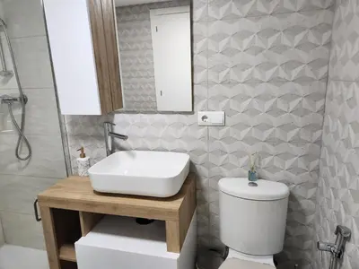 a bathroom with a sink and a toilet and a mirror at Apartment in Vera with rooftop pool in Valencia