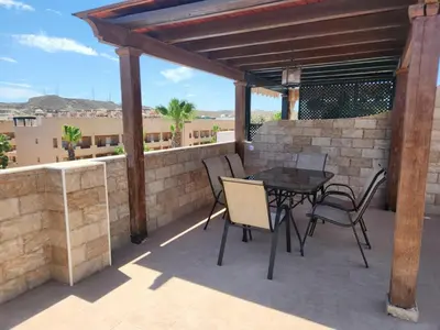 a patio with a table and chairs on a brick wall at Apartment in Vera with rooftop pool in Valencia