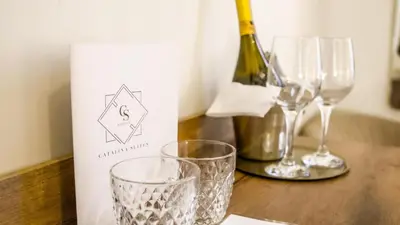a bottle of wine and two glasses on a table at Hotel Catalina Suites in Valencia