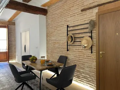 a dining room with a table and chairs and a brick wall at Apartamentos Valencia Centro 1 in Valencia