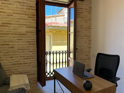 a desk with a laptop on it next to a balcony at Apartamentos Valencia Centro 1 in Valencia