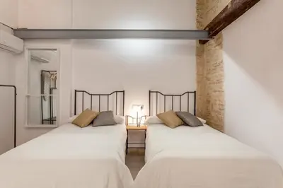 two beds in a room with white walls at Bolseria Ciutat Vella in Valencia