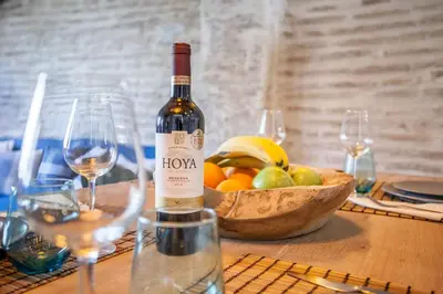 a bottle of wine sitting on a table with a bowl of fruit at Bolseria Ciutat Vella in Valencia