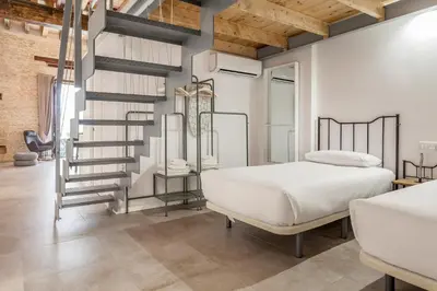 a bedroom with a bed and a spiral staircase at Bolseria Ciutat Vella in Valencia