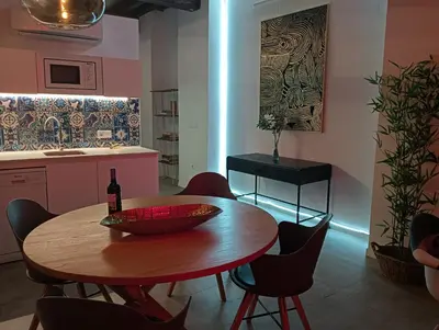 a dining room with a table and a bottle of wine at Bolseria Ciutat Vella in Valencia