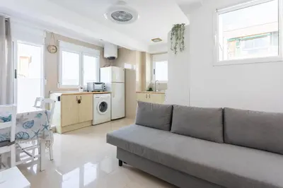 a living room with a couch and a kitchen at Seaview Apartment N12 in El Perelló