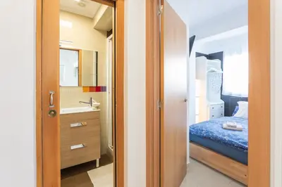 a small bedroom with a bed and a sink at Seaview Apartment N12 in El Perelló