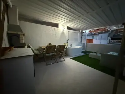 a room with a kitchen and a table and chairs at Duplex Ático con terraza y BBQ in Puerto de Sagunto