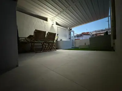 an empty patio with two chairs in a garage at Duplex Ático con terraza y BBQ in Puerto de Sagunto