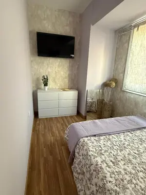 a bedroom with a bed and a tv on the wall at Duplex Ático con terraza y BBQ in Puerto de Sagunto