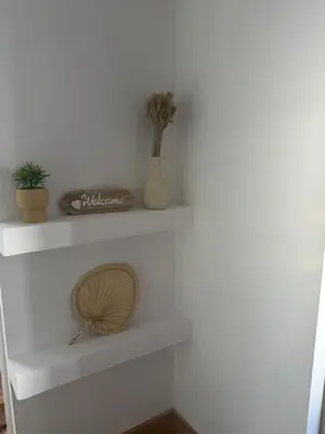 a white shelf with plants and a fan on it at Duplex Ático con terraza y BBQ in Puerto de Sagunto