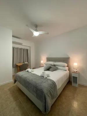 a bedroom with a large white bed and a table at Valentia Rooms - Baleares in Valencia