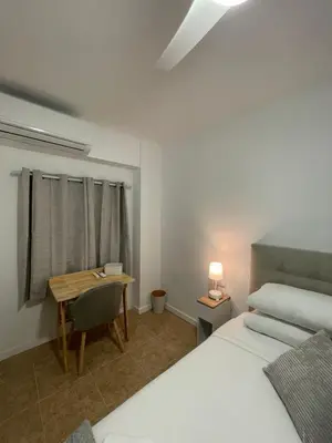 a bedroom with a bed and a table and a desk at Valentia Rooms - Baleares in Valencia