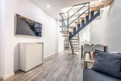 a living room with a couch and a staircase at Duplex-Port-Valencia 14 in Valencia