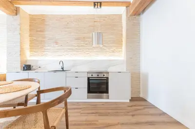 a kitchen with white cabinets and a table and a sink at Yturralde by Alma Suites in Valencia