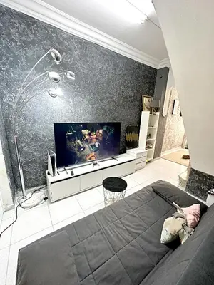 a living room with a tv and a bed at La montaña del sol in Sueca