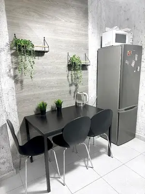 a black table and chairs in a kitchen with a refrigerator at La montaña del sol in Sueca