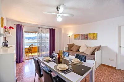a living room with a dining table and a couch at Florazar 2 Pool & Private Balcony in Cullera