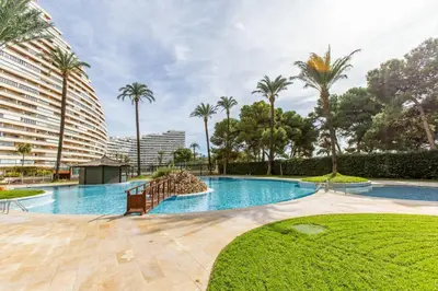 a swimming pool with palm trees and a building at Florazar 2 Pool & Private Balcony in Cullera