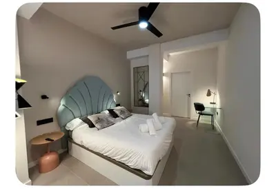 a bedroom with a large bed with a blue headboard at Cosy apartment between beach and city centre in Valencia