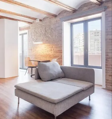 a couch in a living room with a brick wall at increible ubicación in Valencia