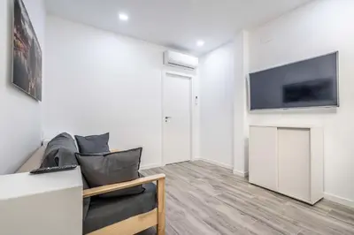 a living room with a couch and a tv on a wall at Duplex-Port-Valencia in Valencia