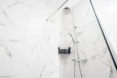 a shower in a white bathroom with marble walls at Duplex-Port-Valencia in Valencia