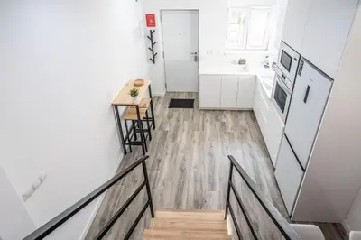 a staircase leading to a kitchen with white walls and wood floors at Duplex-Port-Valencia in Valencia